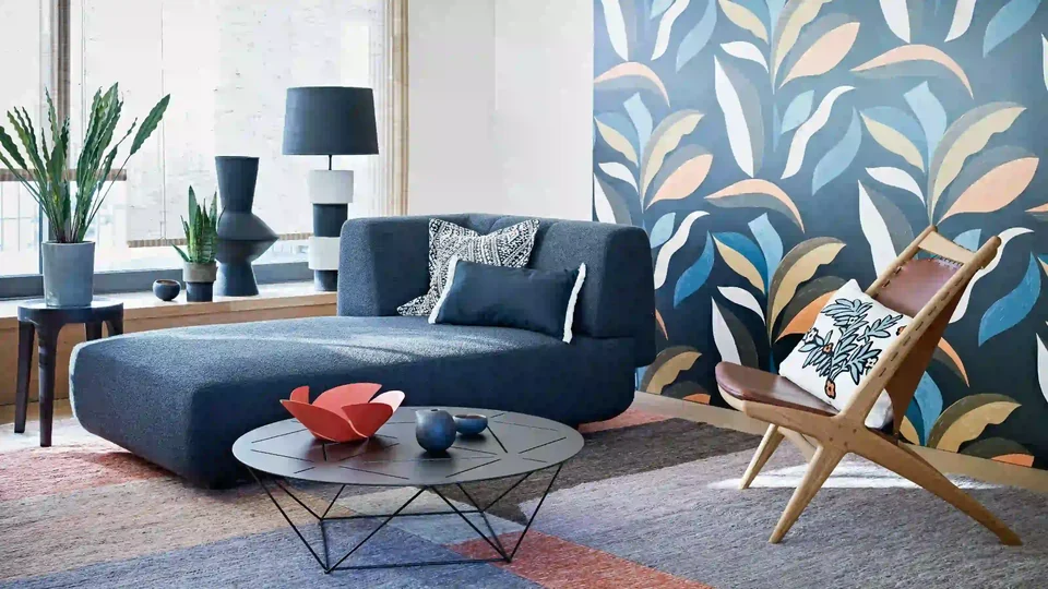Colorful oversized leaf wallpaper above a low modern sofa